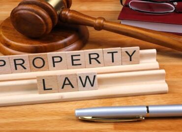 Gavel and pen beside “property law” blocks, representing property law and conveyancing.