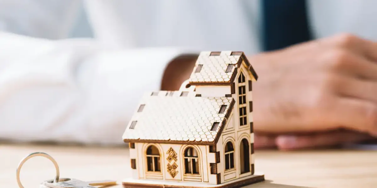 House model with keys on the table symbolising conveyancing and property transfer.