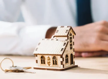 House model with keys on the table symbolising conveyancing and property transfer.
