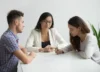 A couple signing a divorce agreement with a lawyer during a consultation.