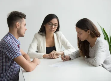 A couple signing a divorce agreement with a lawyer during a consultation.